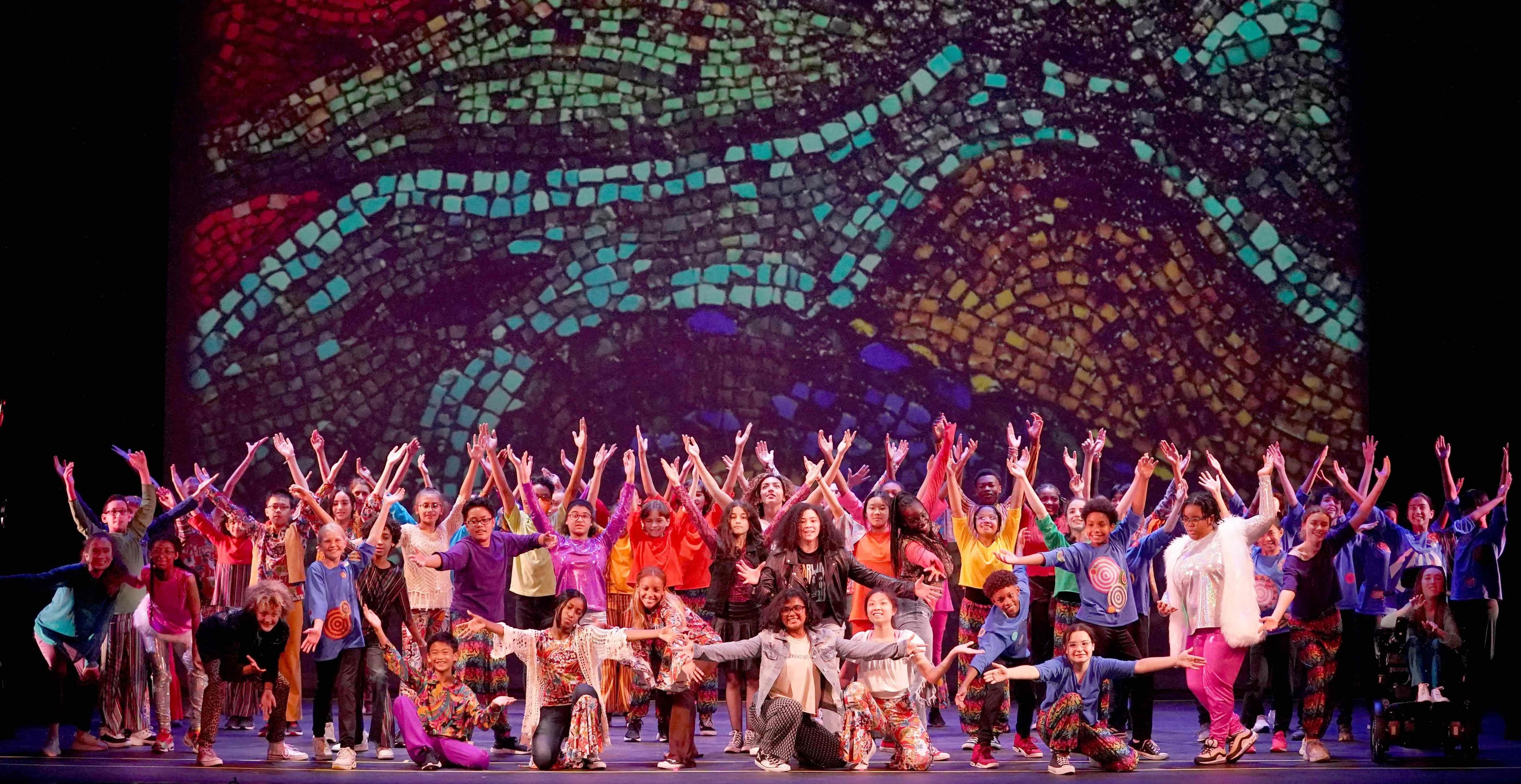 People on a stage raising their arms