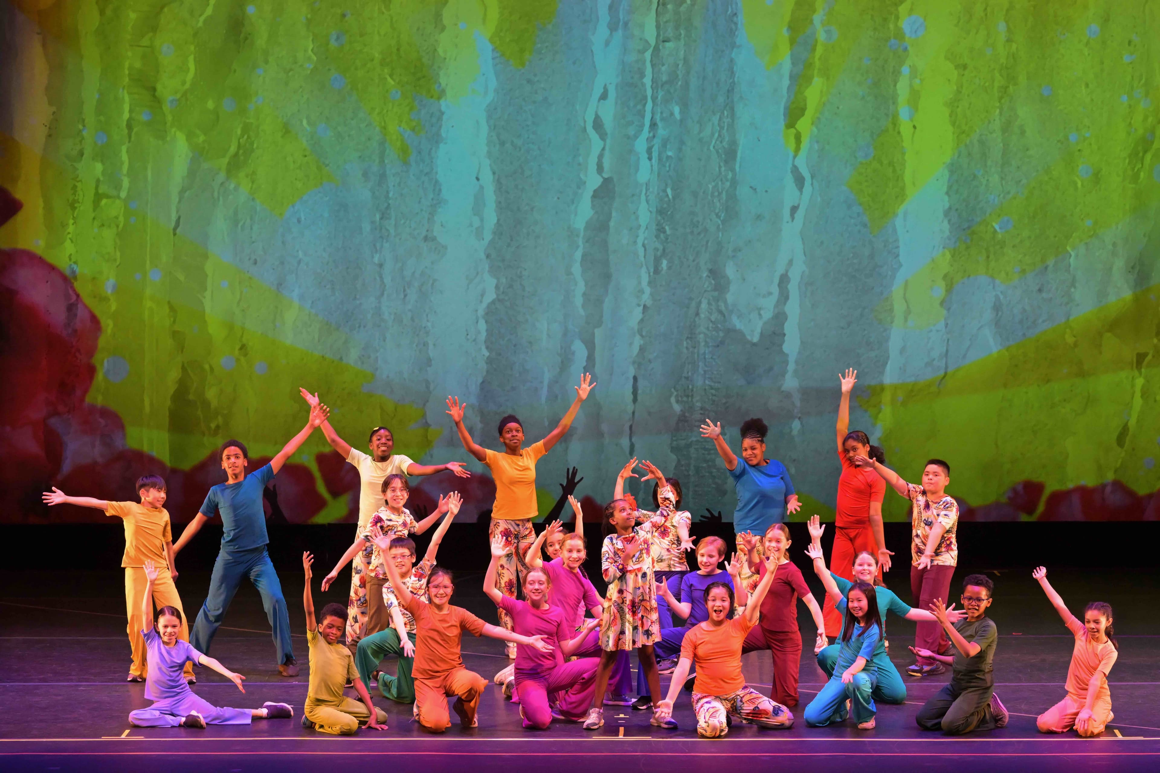 Kids on stage with arms in air